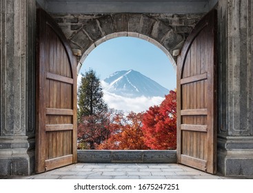 Open large wooden door with mount Fuji-san and autumn maple tree in blue sky at Japan