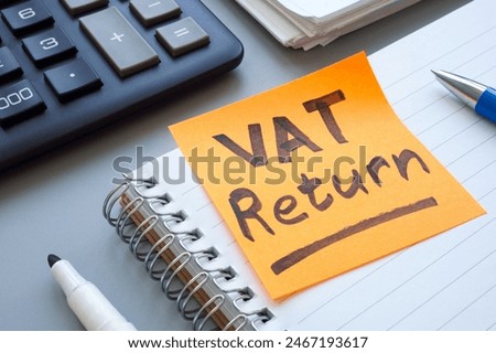 Open ledger and sticky note with words VAT return.