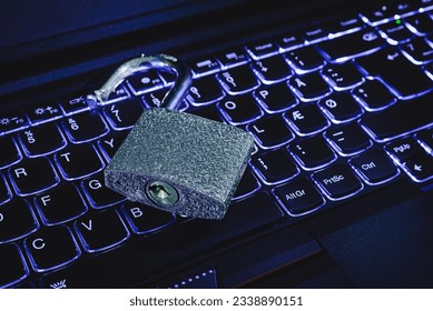 Open lock on keyboard.Hacker attack,padlock on computer keyboard,symbol of cyber security information leak concept.Closeup,selective focus,toned,indoors shot.