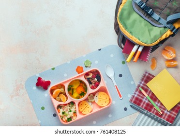 Open Lunch Box With Healthy Kid's Lunch With Vegetable Soup, Couscous Salad And Funny Sandwiches Near School Backpack On Beige Background With Blank Space For Text; Top View, Flat Lay