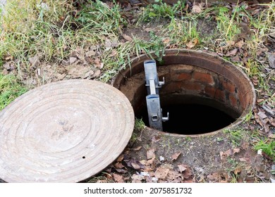 An Open Manhole Of The City Sewer And A Ladder Lowered Into It