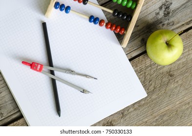 Open math notebook with colored counting abacus and steel compass and pencil and green apple on wooden background - Powered by Shutterstock - Get 15% off with code: PIKWIZARD15