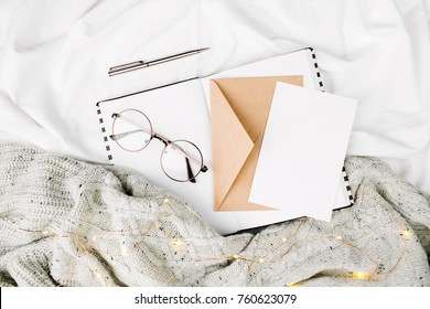 Open Mockup Planner And Glasses On Bed With Warm Plaid. Copy Space. Flat Lay, Top View