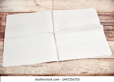 Open Newspaper With Blank Unprinted Pages Lies On Wood