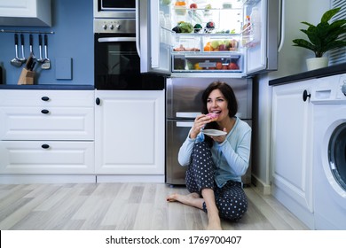 Open Night Sweet Indulgence. Woman Eating Near Refrigerator