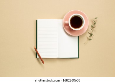 Open Note Book With Cup Of Coffee On Beige Background. Flat Lay, Top View, Copy Space