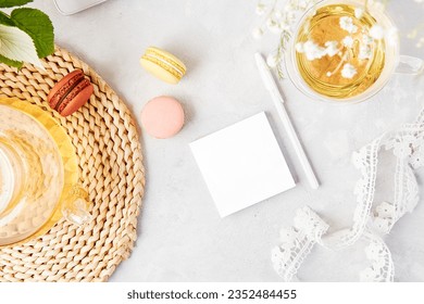 Open note mock up, herbal tea and earphones. Freelance, to do list, shopping list concept. Aesthetic tea time, feminine meditative lifestyle, cozy home. Copy space.