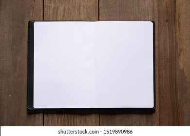 open notebook or book with empty pages on wood background, top view.