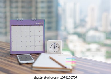 Open Notebook Calendar June 2018 with smartphone diary clock pencil blurred background modern office. Event organizer midyear half year planning, timetable, schedule. Calendar 2018 Concept.