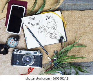 Open notebook with drawings (Asia map), Vintage camera, smartphone, pencil, Passport, compass. palm leaves.  Asia - travel concept , Toned image - Powered by Shutterstock