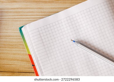 An open notebook on a table intended for study or business with pen