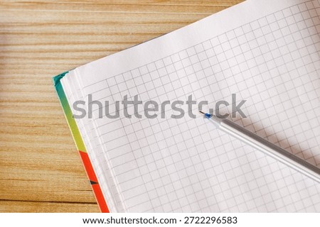 An open notebook on a table intended for study or business with pen