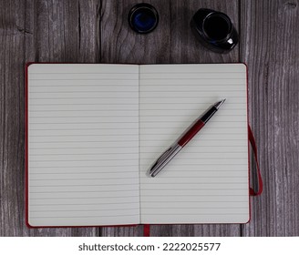 open notebook with pen and inkwell for writing. on wooden background. space to write. top view - Powered by Shutterstock