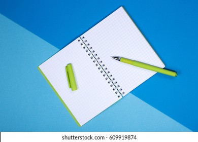 Open notebook and pen on a colored background	