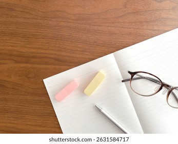 An open notebook with a pen and sticky notes on a desk