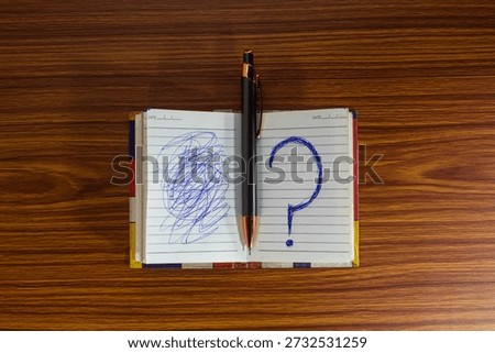 Open Notebook With Question Mark and Scribble Representing Confusion and Problem Solving