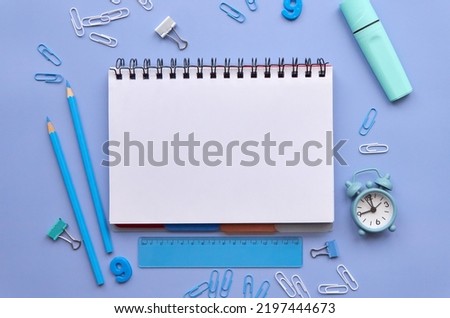 Open notebook and school supplies products accessories isolated on pastel lavender pink background, trendy flatlay, top view. Stationery stuff equipment for education. Back to school concept.
