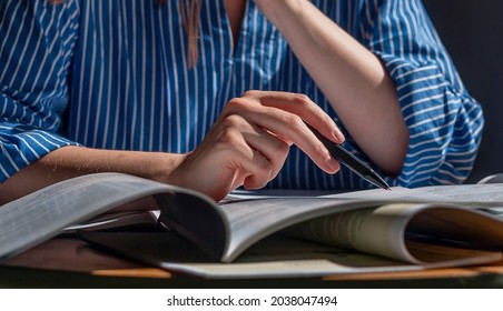 Open notebooks, books, textbooks closeup. Education and research concept. Female hand with pen taking notes, reading.