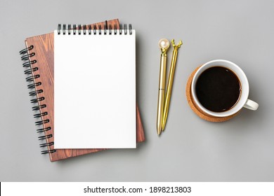 open notepad, cup of coffee, golden pen moose on gray background spiral notebook on table Business, planning, education, morning life working from home concept Top view Flat lay Mock up - Powered by Shutterstock