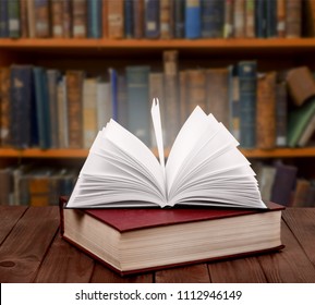 Open old book on a bookshelf background - Shutterstock ID 1112946149