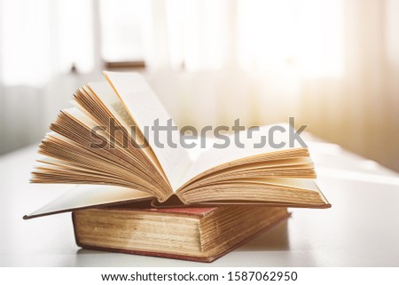Open old book on the table In the library background