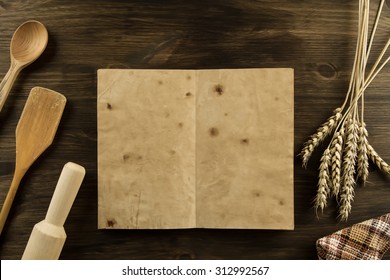 Open Old Vintage Book On The Aged Wooden Background. Kitchen Utensils, Wheat, Cloth. Homemade, Menu, Recipe, Mock Up