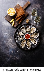 Open Oysters with bread and butter and champagne on dark texture background copy space