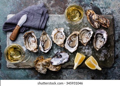 Open Oysters Fines de Claire on stone plate with lemon