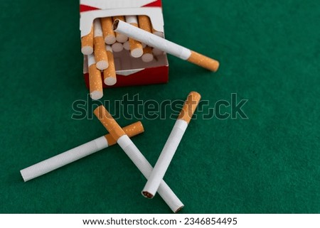 open pack of cigarettes standing isolated green