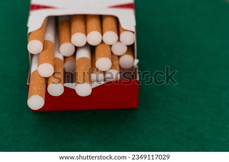 open pack of cigarettes standing isolated green