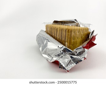 Open package of crackers with a visible layer. The package is made of silver foil and red plastic.