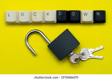 an open padlock with keys on a yellow background at the top the inscription lockdown is laid out from the keys of a computer keyboard the concept of data protection prohibitions. High quality photo