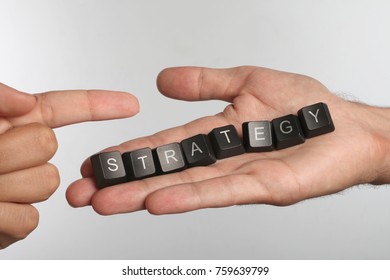 Open palm with eight computer buttons with word STRATEGY and pointing finger