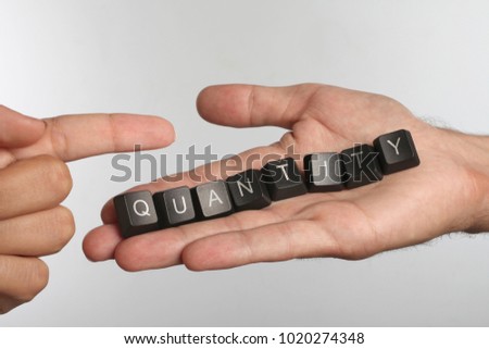 Open palm with eight computer buttons with word QUANTITY and pointing finger