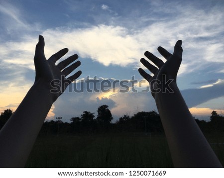 Open the palm of the hand on sunset sky background. Pray, Respect, God Concept