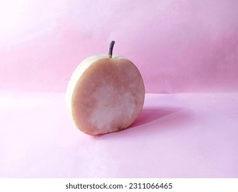 The open pieces of the pear are too long to brown the flesh. Pink background - Shutterstock ID 2311066465