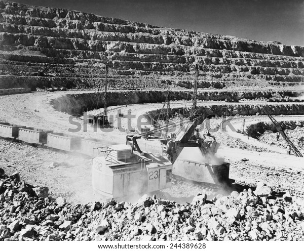 Open pit copper mine at\
Chuquicamata, Chile. Photo shows a crane steam shovel strip mining\
raw copper ore and depositing it into open railroad cars. Ca.\
1945.