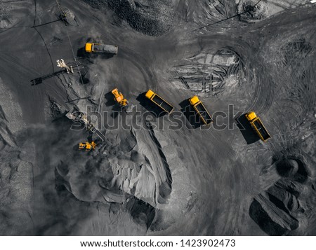 Open pit mine, coal loading in trucks, transportation and logistics, top view aerial.