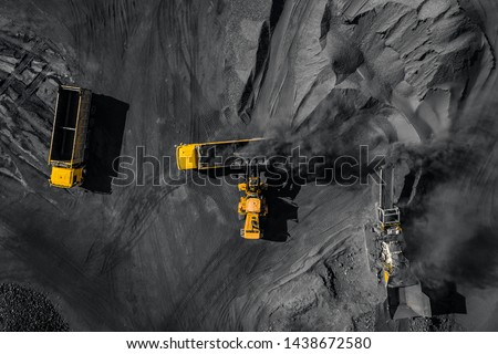 Open pit mine, coal loading in trucks, transportation and logistics, top view aerial drone.