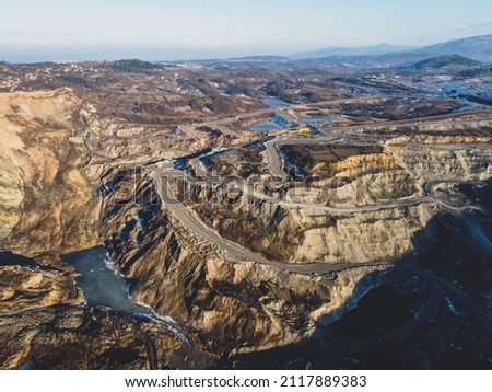Open pit mine. Coal mining, aerial drone view. Trucks carry ore. Mining industry.