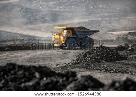 Open pit mine industry. Big yellow mining truck for coal moving on road career.