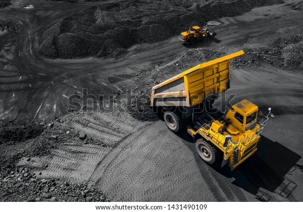 Open pit mine industry, big yellow mining\
truck for coal, top view aerial\
drone.
