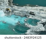 Open pit mine industry. Limestone quarry with backhoe and truck in operation. Heavy machinery in mining industry and construction material supply. Landscape of resource extraction in a industrial site