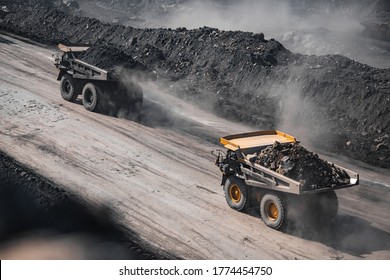 Open Pit Mine Industry. Yellow Mining Truck For Coal Moves Along Dusty Quarry Road.