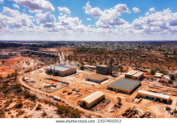 Open pit minerals and metal\
ore Junction Mine in Broken hill silver city - elevater aerial\
cityscape.