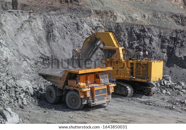 Open pit mining\
of iron ore and magnetite ores.Loading the iron ore into heavy dump\
truck at the opencast\
mining.