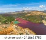 Open pit nickel mine and burgundy water lake. Polluted air and water. Mindanao, Philippines.