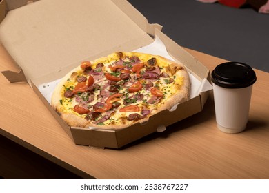 Open pizza box with a freshly baked pizza topped with tomatoes, sausage, ham, and herbs on a wooden table. A takeaway coffee cup is placed next to it. Perfect for food delivery and casual dining theme - Powered by Shutterstock