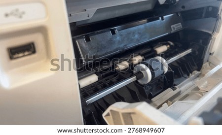 Open printer interior with rollers and ink components visible. White casing and mechanical parts in clear view. Detail shot emphasizes printer's internal structure