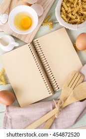 Open Recipe Book On Green Wooden Table With Copy Space, Top View